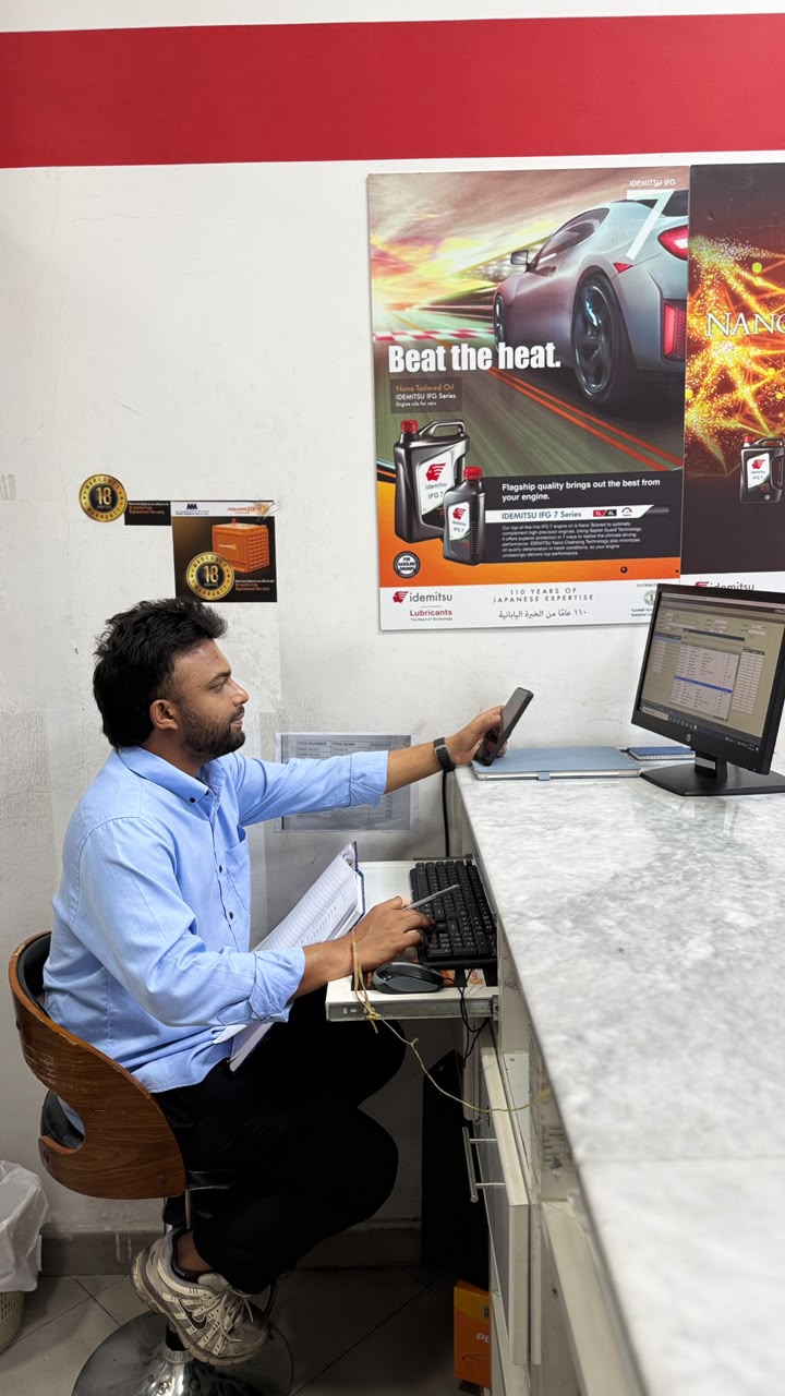 Harshad working at a sales counter with a computer and phone